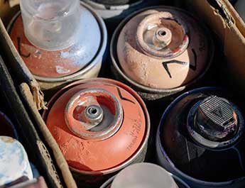 spray paint bottles in a cardbaord box