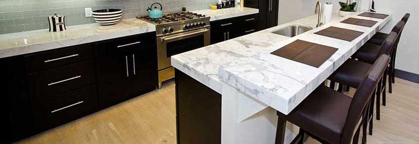 white kitchen countertop with milky appearance and contrasting black cabinets and chairs