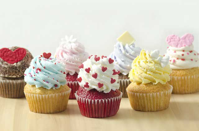 Beautiful cup cakes with red, white, and yellow frosting on top made from cup cake maker.