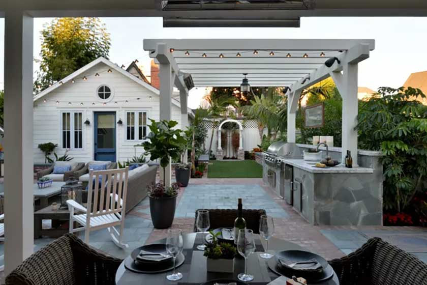 white house with white outdoor kitchen and green plants around