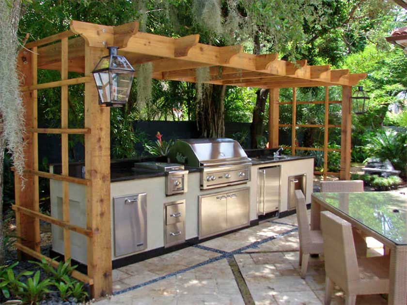 entire outdoor kitchen with gril and wooden frame on top of countertop and grill.