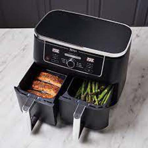 A black colored air fryer with a temperature controlling noob in the center is a small kitchen appliance.