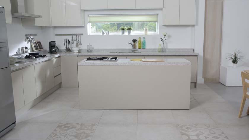 A modernistic designed kitchen with installed kitchen cabinets and countertops and a window in the center