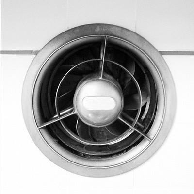 A stainless steel kitchen exhaust fan mounted in the wall.