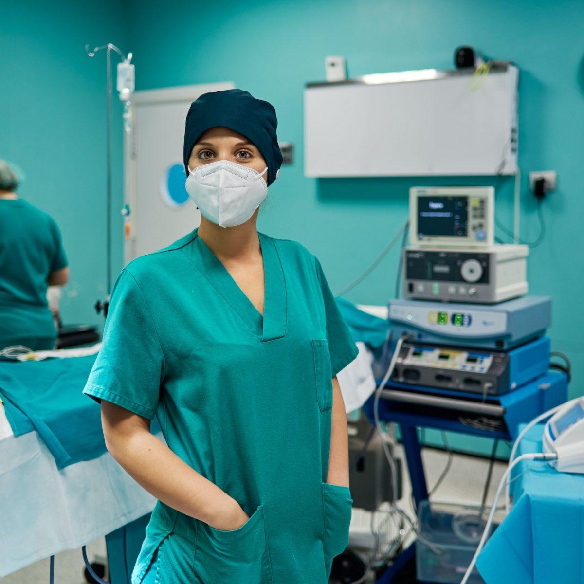 Surgeon in uniform and respiratory mask in clinic